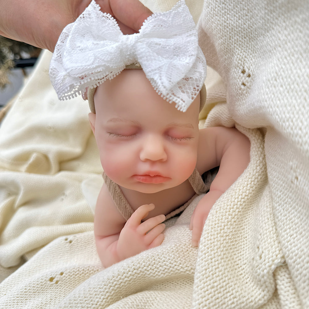 30 cm lebensechte Loulou Reborn Puppe aus Vollsilikon mit geschlossenen Augen im kaffeefarbenen Kleid