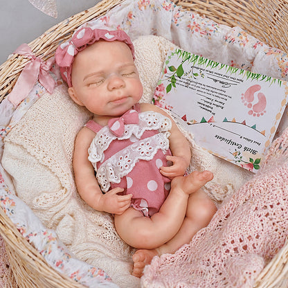 30 cm Pascale Reborn Puppe aus Vollsilikon mit geschlossenen Augen in rosa gepunkteter Kleidung