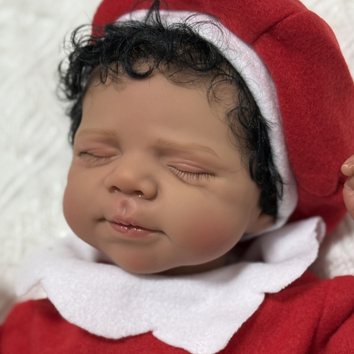 19 Zoll lebensechte Reborn-Puppe mit geschlossenen Augen und dunkler Haut in Weihnachtskleidung - Pascale
