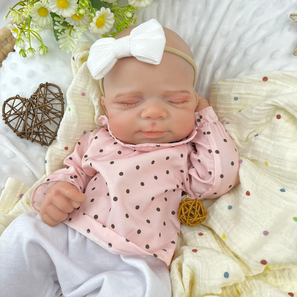 45 cm dehnbare Reborn-Puppe Pascale aus Vollsilikon im Schlaf getragen in einem rosa gepunkteten Outfit