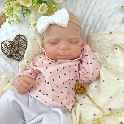 45 cm dehnbare Reborn-Puppe Pascale aus Vollsilikon im Schlaf getragen in einem rosa gepunkteten Outfit