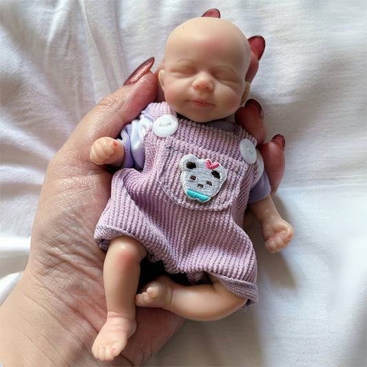 15cm Mini Silikon Reborn Puppe Mädchen Pascale mit geschlossenen Augen im lila Bärenoutfit