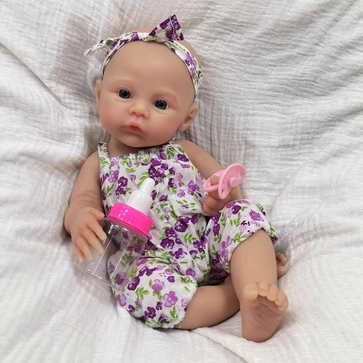 30cm weiches Silikon-Reborn-Baby-Mädchen mit blauen Augen im lila geblümten Kleid - Wiese