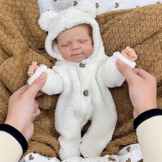 30cm lebensechte Reborn-Puppe Pascale aus Vollsilikon mit geschlossenen Augen in weißer Plüschkleidung