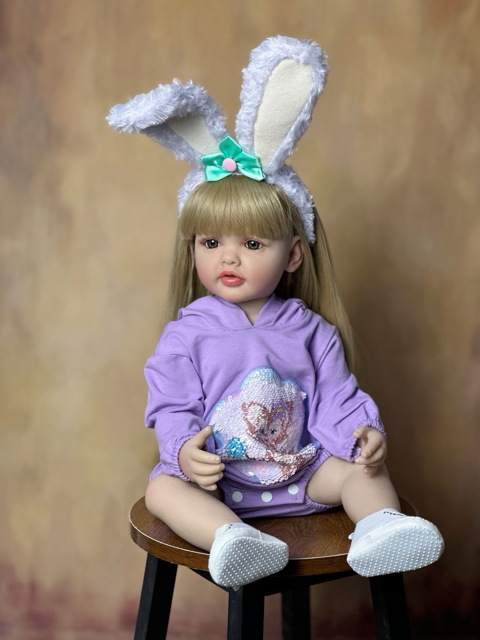 55 cm wiedergeborenes Mädchen mit offenen Augen und langen Haaren in lila Kleidung und Hasenohren-Haarreif - Betty