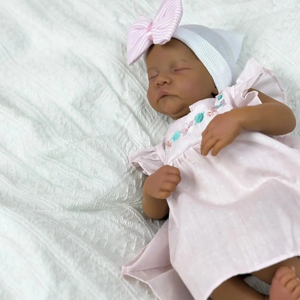 48cm Reborn Babypuppe Levi mit geschlossenen Augen dunkler Haut und weichem Körper im rosa Kleid