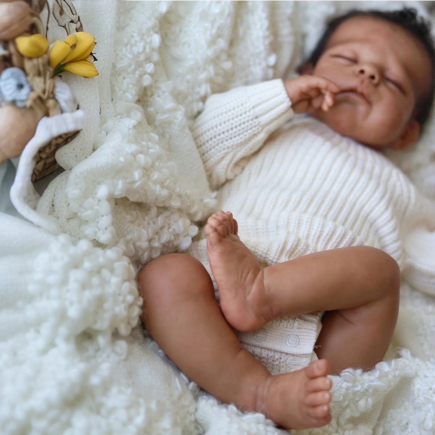 50 cm Reborn Puppe Eric mit geschlossenen Augen dunkler Haut und kurzem Haar im weißen Pullover