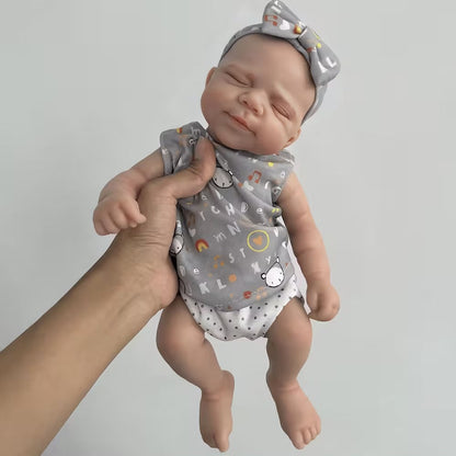 30 cm niedliche Pascale Reborn Puppe aus Vollsilikon in grauem Outfit mit Buchstabenprint.