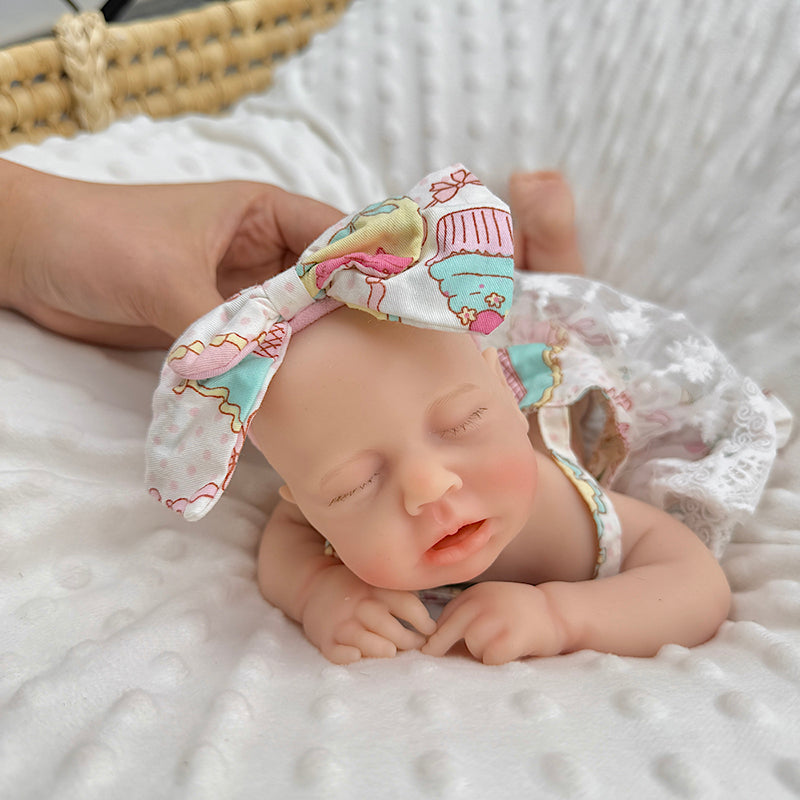 30cm Loulou Reborn Baby aus Vollsilikon mit geschlossenen Augen in einem Spitzenkleid mit Blumenmuster