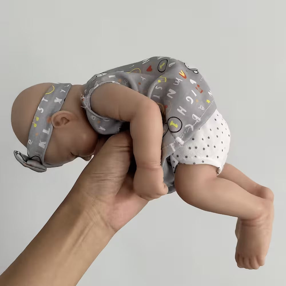 30 cm niedliche Pascale Reborn Puppe aus Vollsilikon in grauem Outfit mit Buchstabenprint.