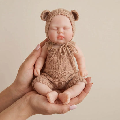 30 cm vollständig aus Silikon gefertigte Reborn Puppe Pickle mit geschlossenen Augen in brauner Kleidung