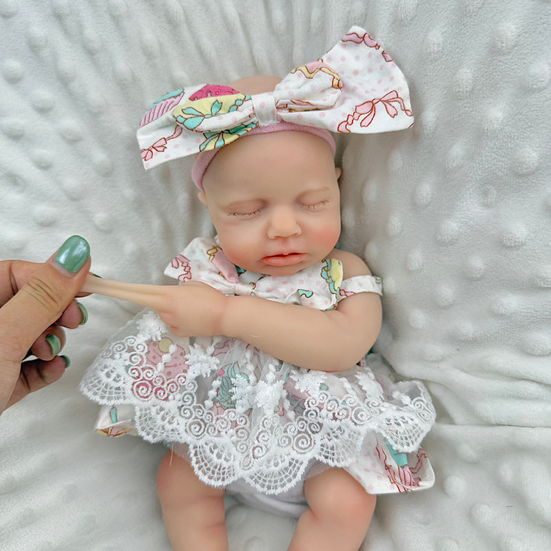 30cm Loulou Reborn Baby aus Vollsilikon mit geschlossenen Augen in einem Spitzenkleid mit Blumenmuster