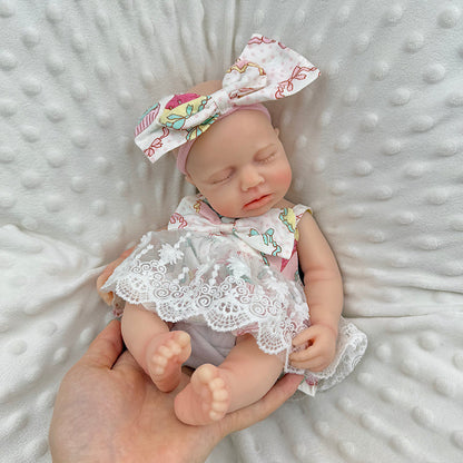 30cm Loulou Reborn Baby aus Vollsilikon mit geschlossenen Augen in einem Spitzenkleid mit Blumenmuster