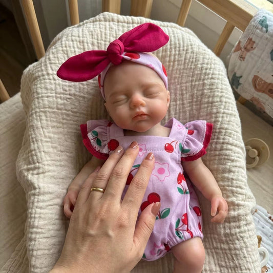 30 cm lebensecht wirkendes Silikon Reborn Baby Mädchen Irys mit geschlossenen Augen im Kirsch-Strampler